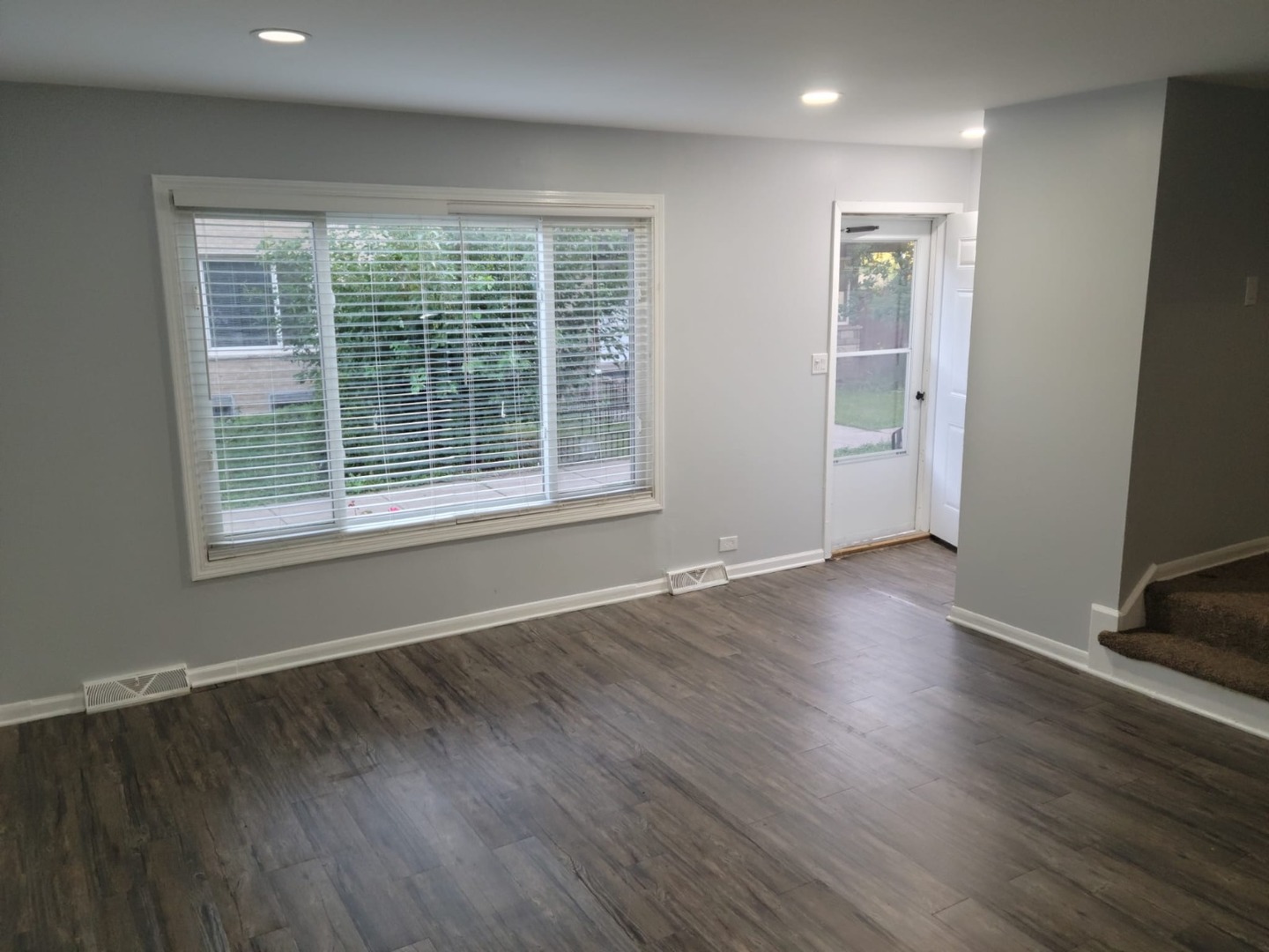 10081 Frontage Road, Unit D Skokie, IL 60077 - Photo 2 of 12 a view of an empty room with wooden floor and a window