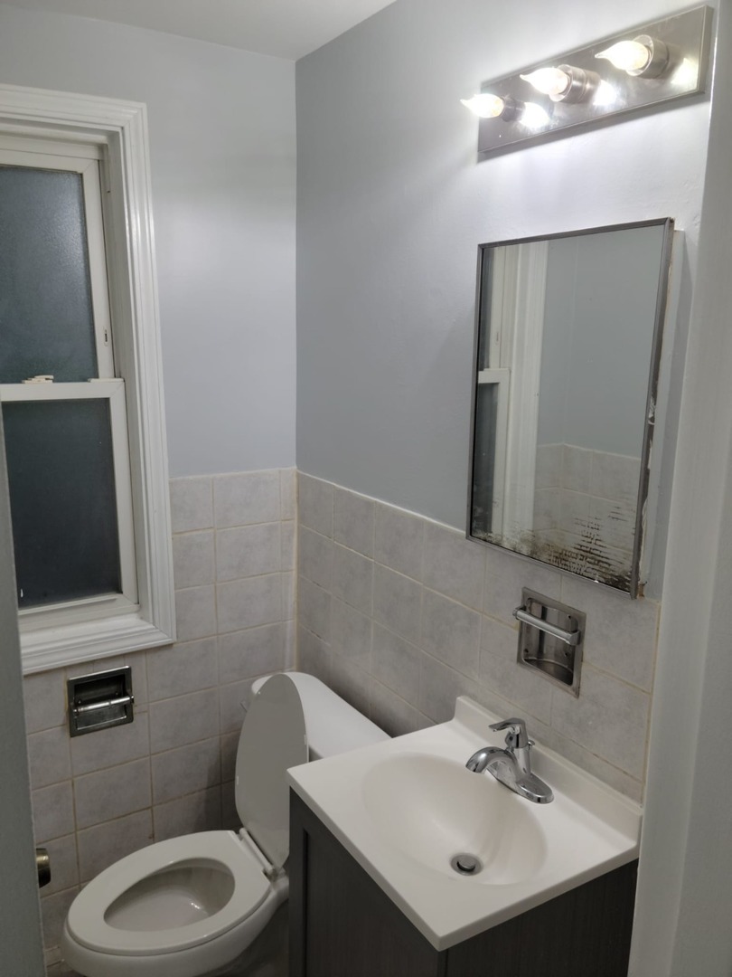 10081 Frontage Road, Unit D Skokie, IL 60077 - Photo 6 of 12 a bathroom with a sink toilet and mirror