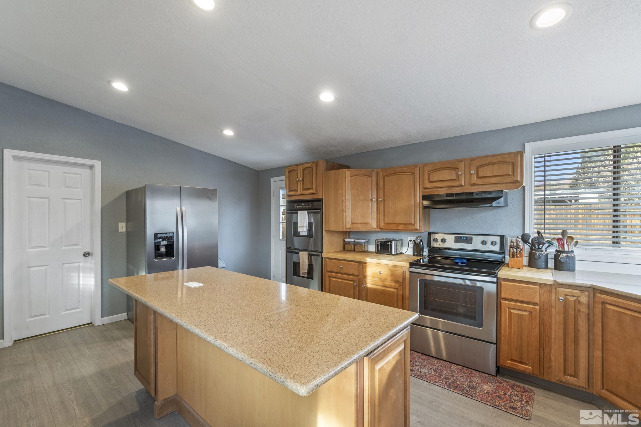 3940 Macaw Lane Reno, NV 89508 - Photo 17 of 35 a large kitchen with stainless steel appliances granite countertop a stove a sink dishwasher and a refrigerator with wooden floor