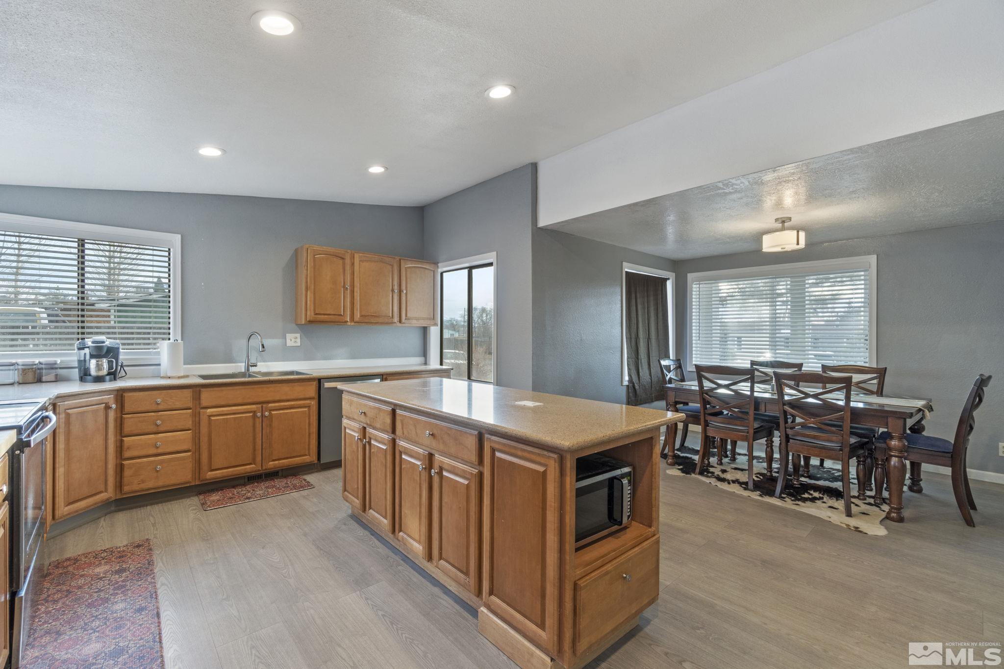 3940 Macaw Lane Reno, NV 89508 - Photo 18 of 35 a large kitchen with stainless steel appliances a stove a sink a oven a dining table and chairs