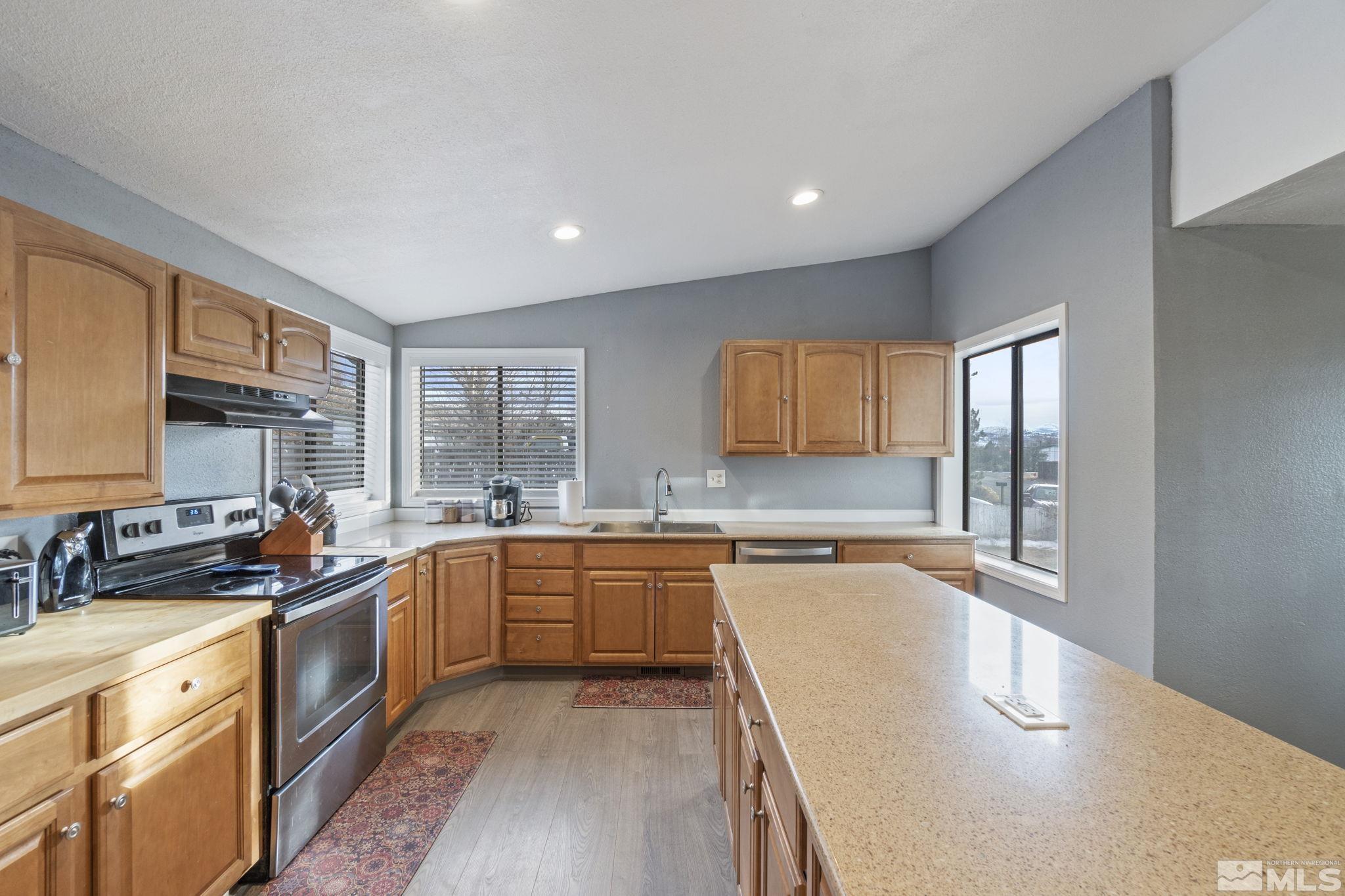 3940 Macaw Lane Reno, NV 89508 - Photo 19 of 35 a large kitchen with stainless steel appliances granite countertop a sink stove and cabinets