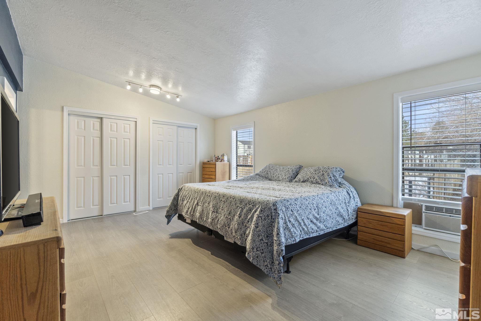 3940 Macaw Lane Reno, NV 89508 - Photo 26 of 35 a spacious bedroom with a bed a couch and a window