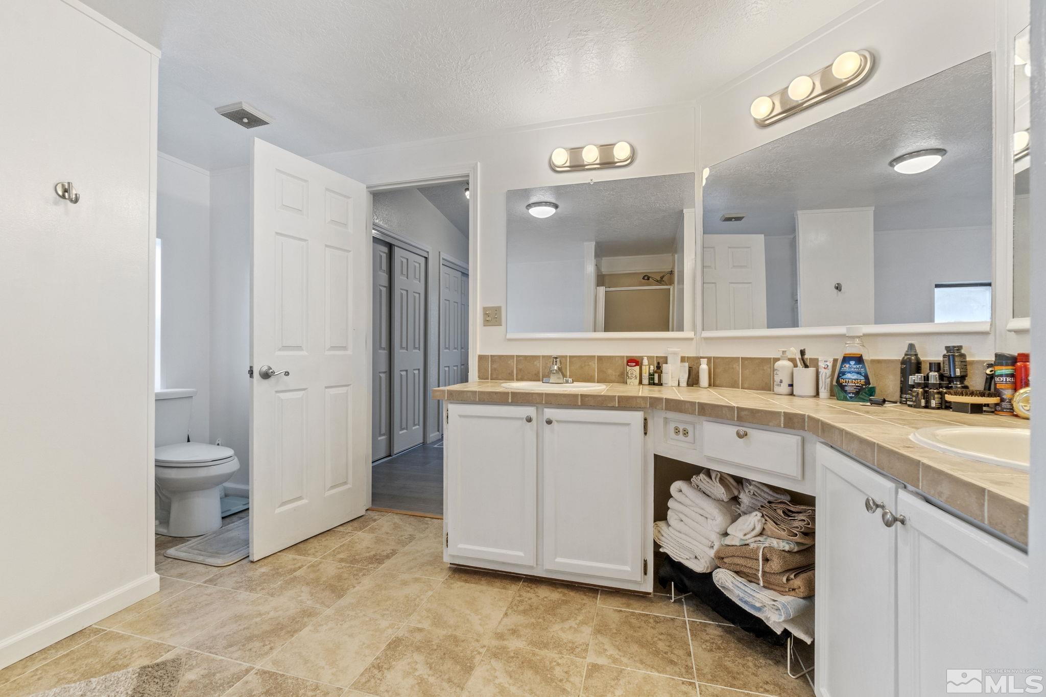 3940 Macaw Lane Reno, NV 89508 - Photo 30 of 35 a spacious bathroom with a granite countertop sink mirror and toilet