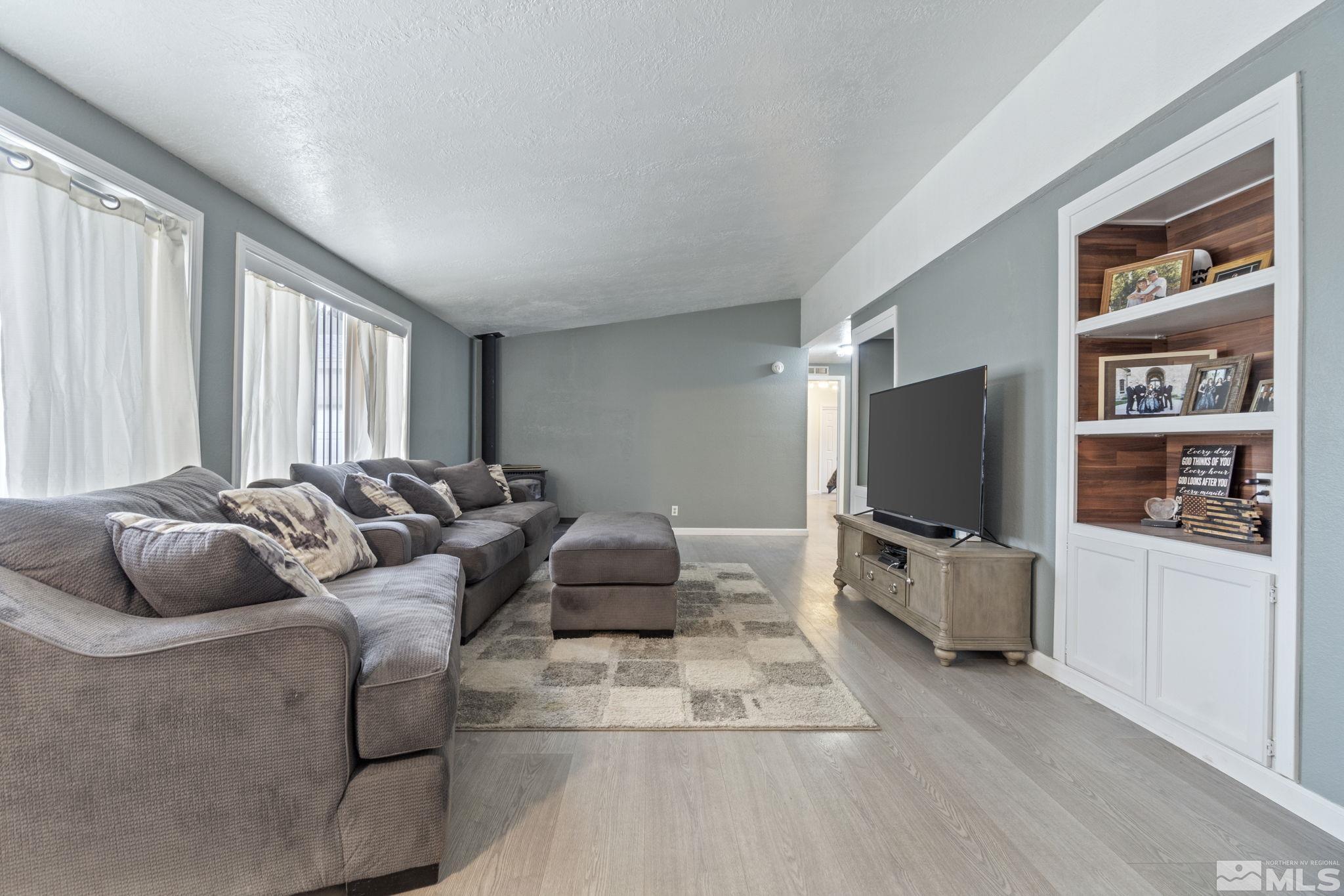3940 Macaw Lane Reno, NV 89508 - Photo 10 of 35 a living room with furniture a flat screen tv and a floor to ceiling window