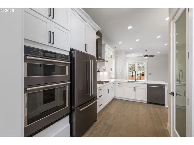 a kitchen with stainless steel appliances kitchen island granite countertop a refrigerator stove and sink
