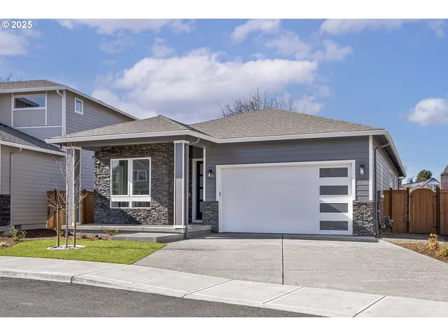a front view of a house with a garden and garage