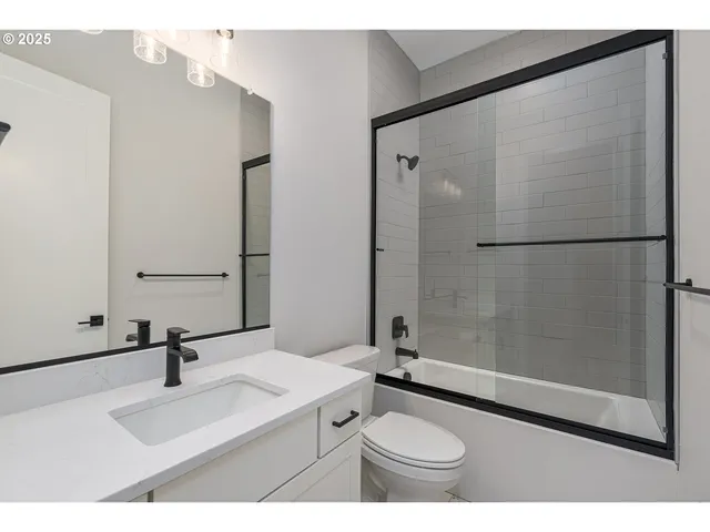 a bathroom with a sink toilet a mirror and shower