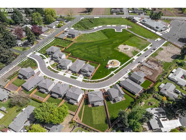 an aerial view of a residential houses with outdoor space and a lake view