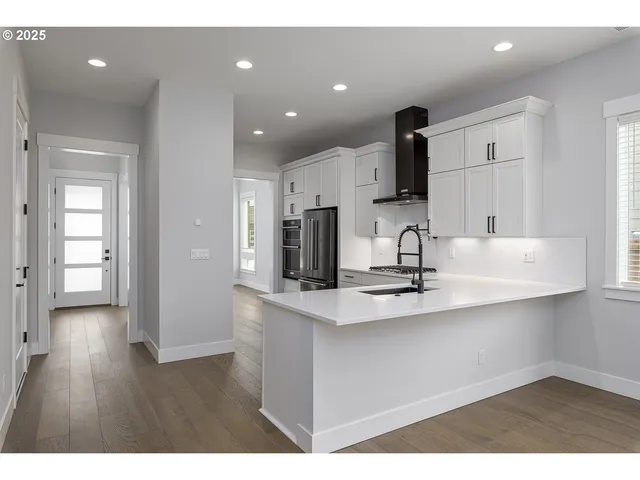 a kitchen with kitchen island white cabinets and stainless steel appliances