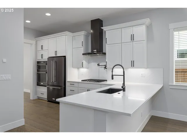 a kitchen with stainless steel appliances a sink stove and refrigerator