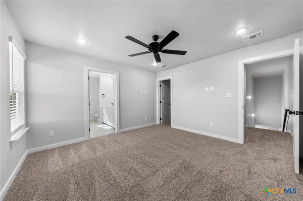 a view of a livingroom with a ceiling fan and window