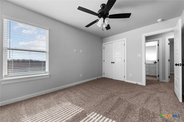 an empty room with a window and a fan