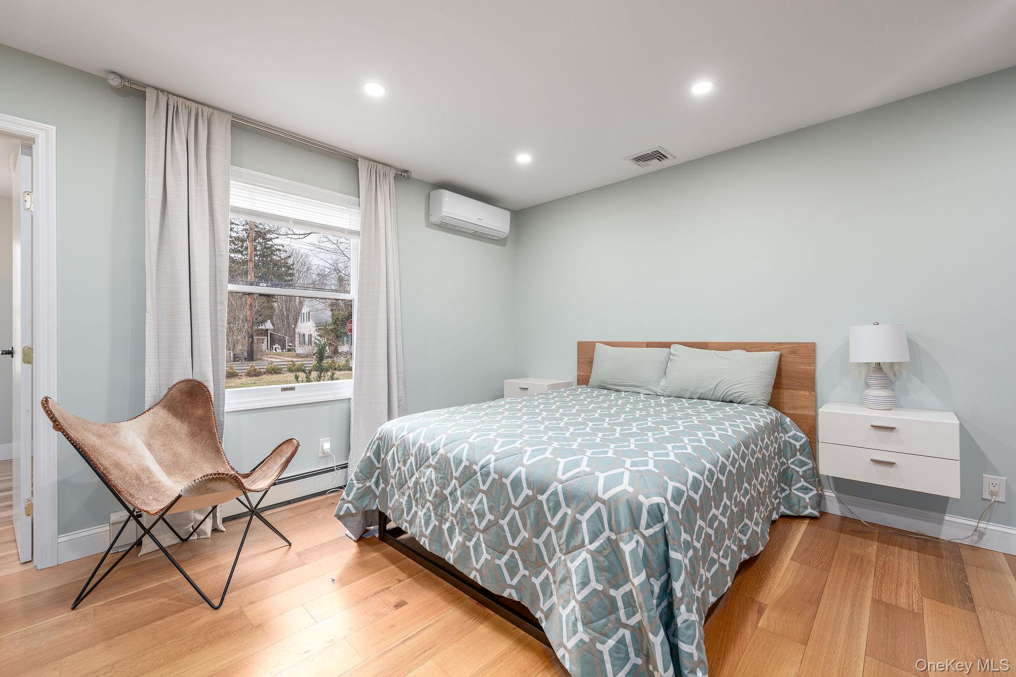 10940 Main Road East Marion, NY 11939 - Photo 13 of 30 a bedroom with a bed and a chair