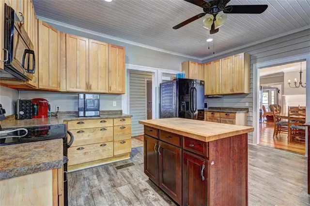 a kitchen with a stove a sink a kitchen island with wooden cabinets and floor