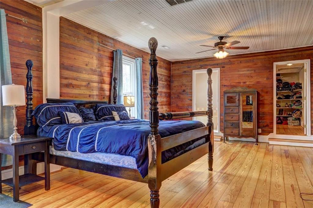 2870 Prospect Road Rutledge, GA 30663 - Photo 44 of 100 a spacious bedroom with a bed a chandelier and flat screen tv