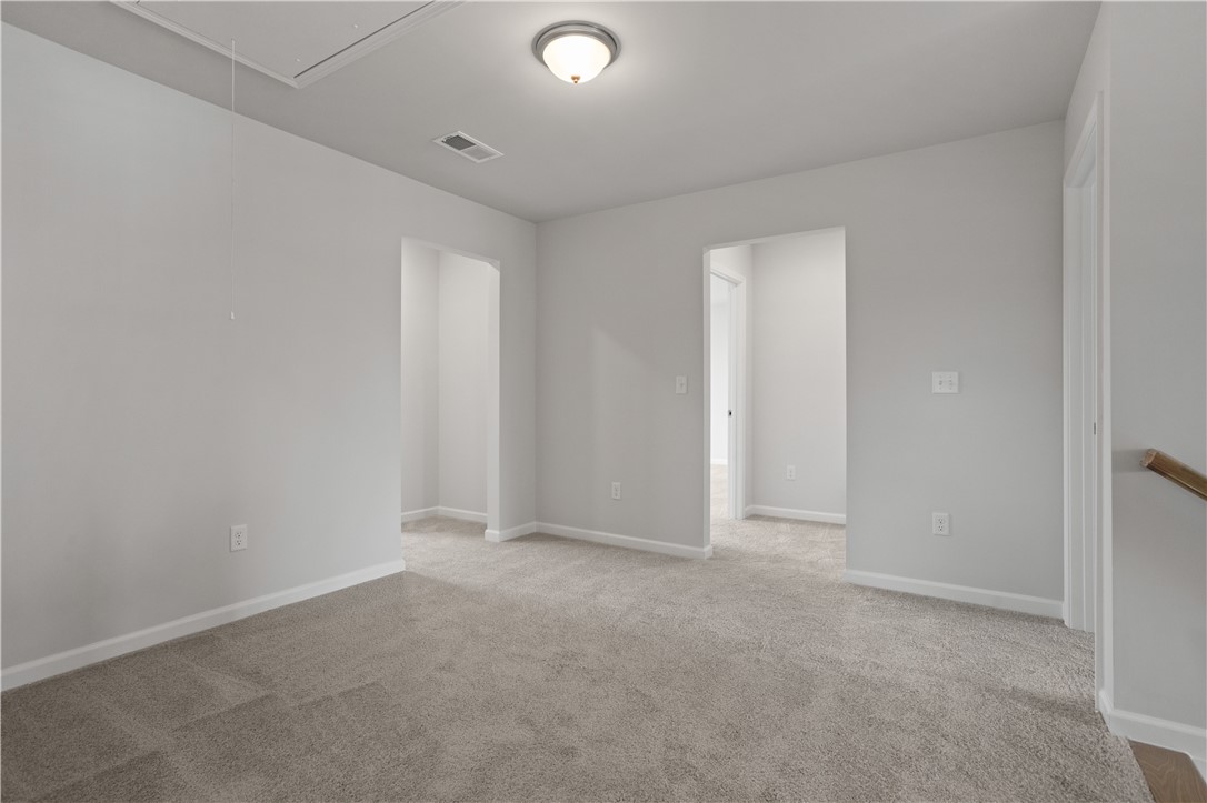 555 Hydrangea Street, Unit LOT 47 Seneca, SC 29678 - Photo 21 of 38 A well-lit, open interior space featuring soft carpeting and a clear pathway to adjacent rooms.