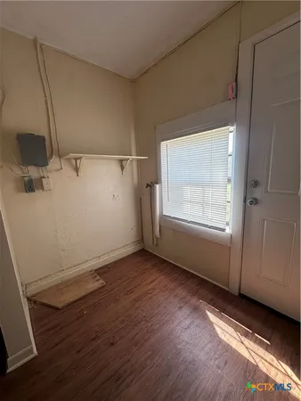 a view of a room with wooden floor and white walls