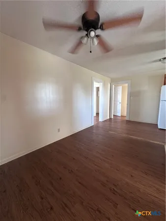 a view of an empty room and a chandelier fan