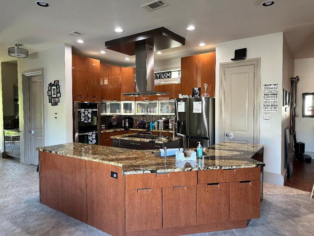 8300 Willow Circle Terrell, TX 75160 - Photo 9 of 14 Kitchen with visible vents, island exhaust hood, a large island with sink, refrigerator with ice dispenser, and stainless steel double oven
