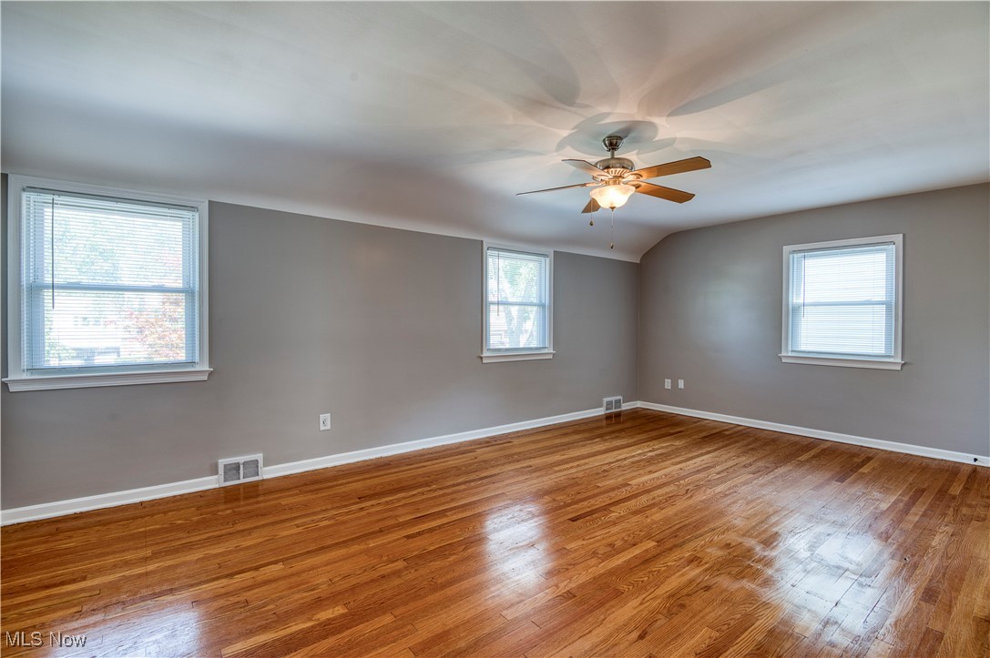 4520 Birchwold Road Cleveland, OH 44121 - Photo 20 of 40 Empty room with hardwood / wood-style flooring, a wealth of natural light, and ceiling fan