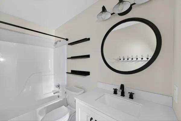 a bathroom with a toilet a sink and a mirror