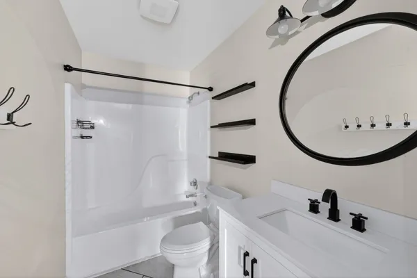 a bathroom with a sink a mirror a toilet and a bathtub