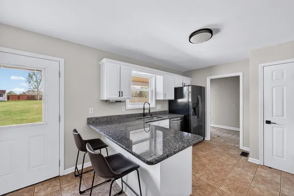 a kitchen with stainless steel appliances granite countertop a sink refrigerator and microwave