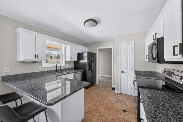 a kitchen with stainless steel appliances granite countertop a sink refrigerator and stove