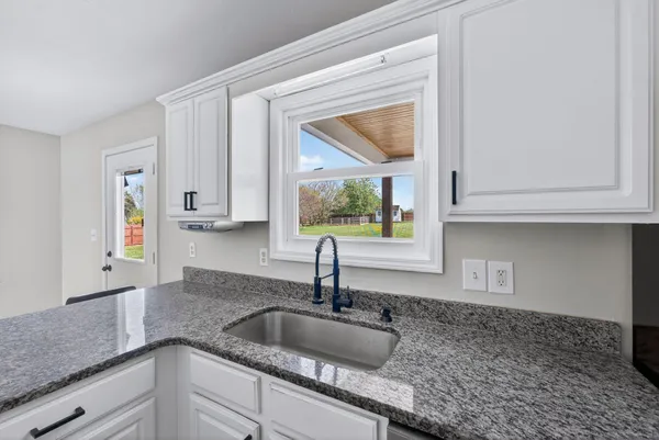 a kitchen with granite countertop a sink and a window