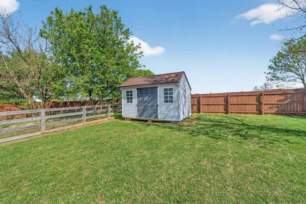 a view of a house with backyard and a garden
