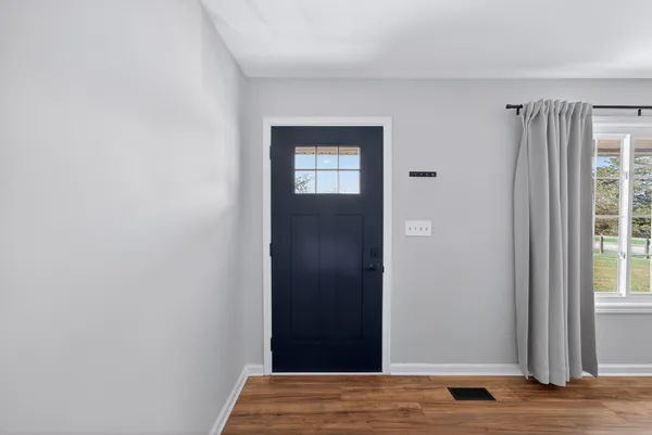 a view of a hallway with wooden floor and a window