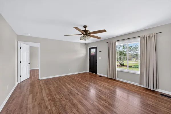 a view of a livingroom with a ceiling fan and window