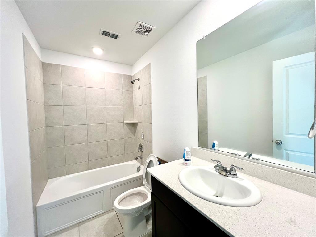 5711 Bristle Leaf Drive Princeton, TX 75407 - Photo 16 of 23 a bathroom with a sink a toilet a mirror a bathtub and shower