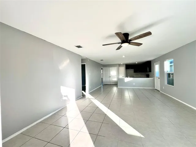 a view of empty room with wooden floor and ceiling fan