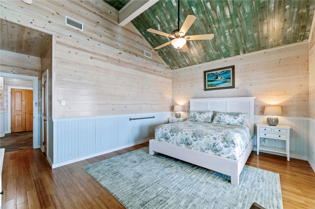 70 Copano Ridge Road Rockport, TX 78382 - Photo 15 of 40 a bedroom with a bed and a wooden floor