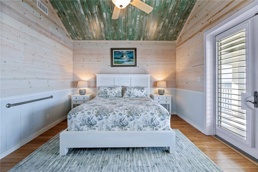 70 Copano Ridge Road Rockport, TX 78382 - Photo 16 of 40 a bedroom with a bed and wooden floor