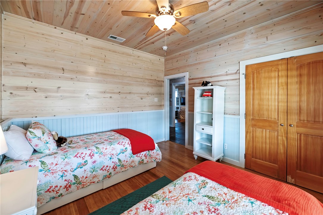 70 Copano Ridge Road Rockport, TX 78382 - Photo 23 of 40 a bedroom with a bed and a chandelier