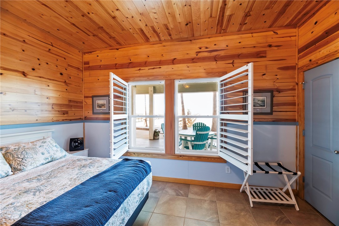 70 Copano Ridge Road Rockport, TX 78382 - Photo 28 of 40 a spacious bedroom with a bed and wooden floor