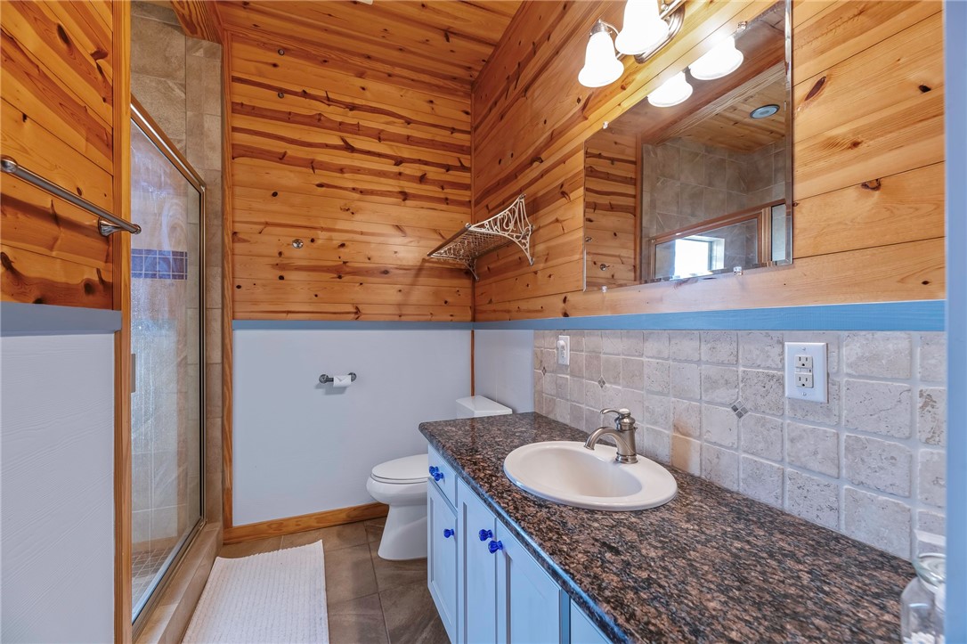 70 Copano Ridge Road Rockport, TX 78382 - Photo 30 of 40 a bathroom with a granite countertop sink and a mirror