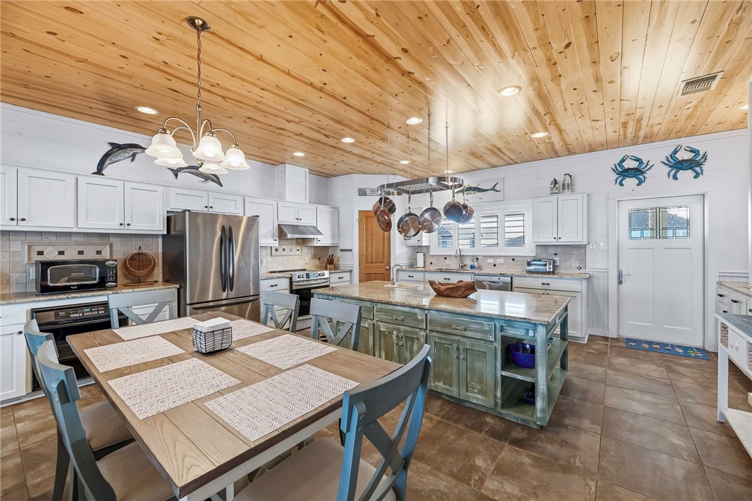 70 Copano Ridge Road Rockport, TX 78382 - Photo 10 of 40 a kitchen with refrigerator and chairs