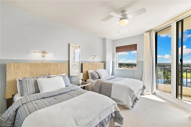 a bedroom with two beds and a large window with outer view