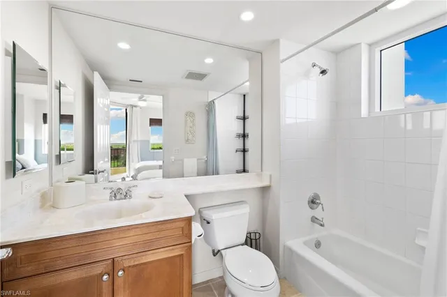 a bathroom with a bathtub shower sink mirror vanity and toilet