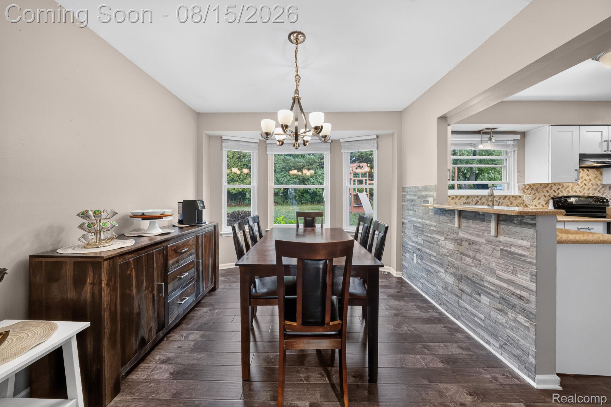 385 Arlington Drive Rochester, MI 48307 - Photo 22 of 47 Recessed lighting, wood-finish flooring, bay windows, stone-look accent wall, and a decorative chandelier