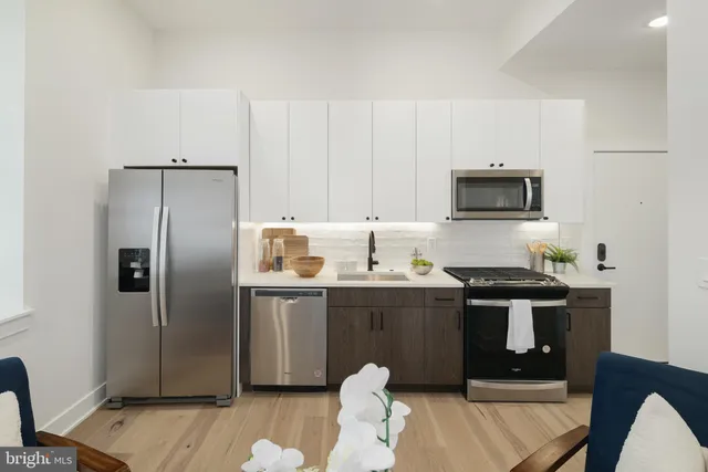 a kitchen with stainless steel appliances a stove a refrigerator and a sink