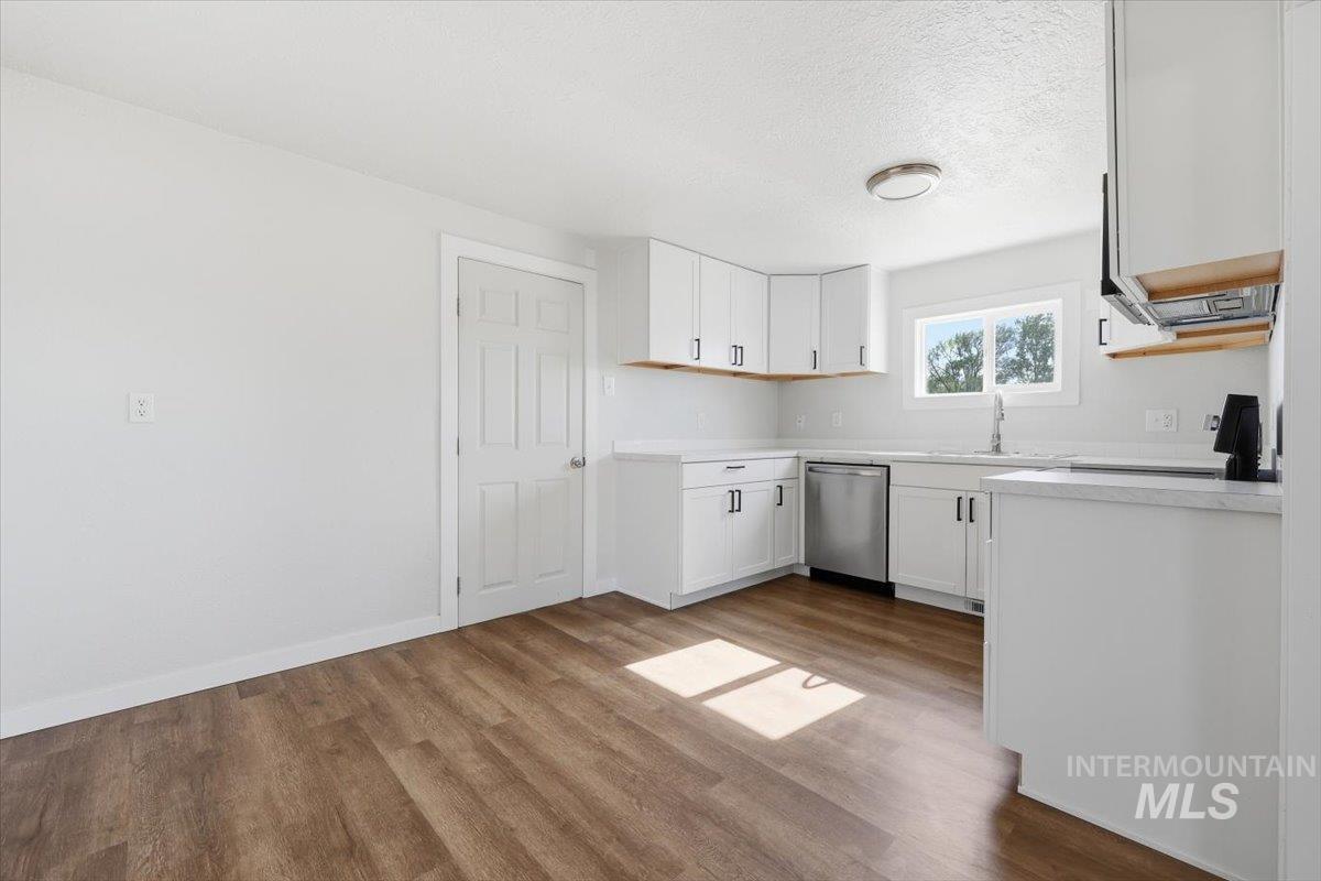 956 Southeast Hamilton Road Mountain Home, ID 83647 - Photo 14 of 34 Contemporary kitchen featuring white cabinetry, quartz-finish countertops, stainless steel dishwasher, wood-finish flooring, and recessed lighting