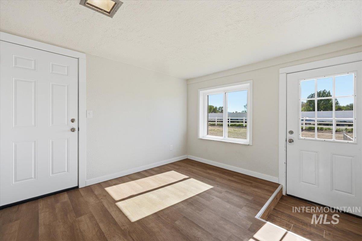 956 Southeast Hamilton Road Mountain Home, ID 83647 - Photo 17 of 34 Entryway featuring wood-finish flooring, a white six-panel door, and a white door with nine-pane window detail