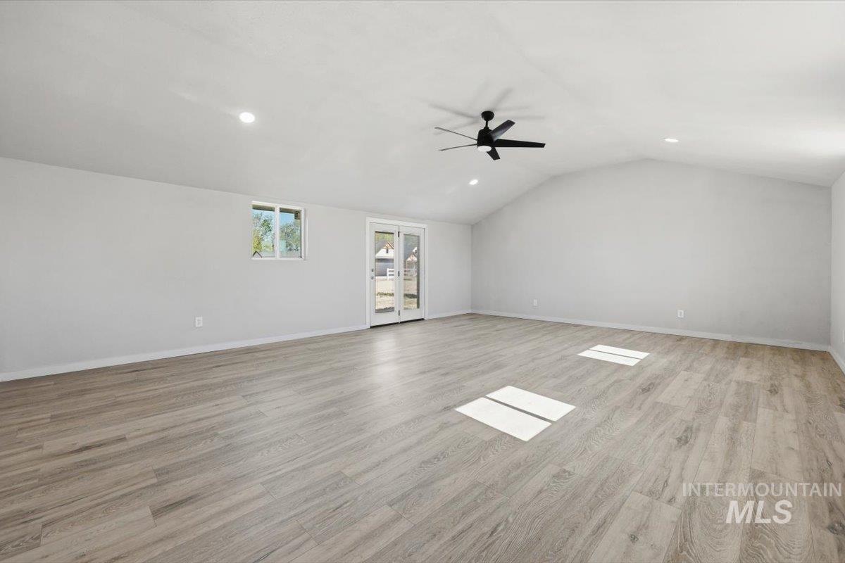 956 Southeast Hamilton Road Mountain Home, ID 83647 - Photo 21 of 34 Spacious room featuring vaulted ceilings, recessed lighting, and wood-finish flooring