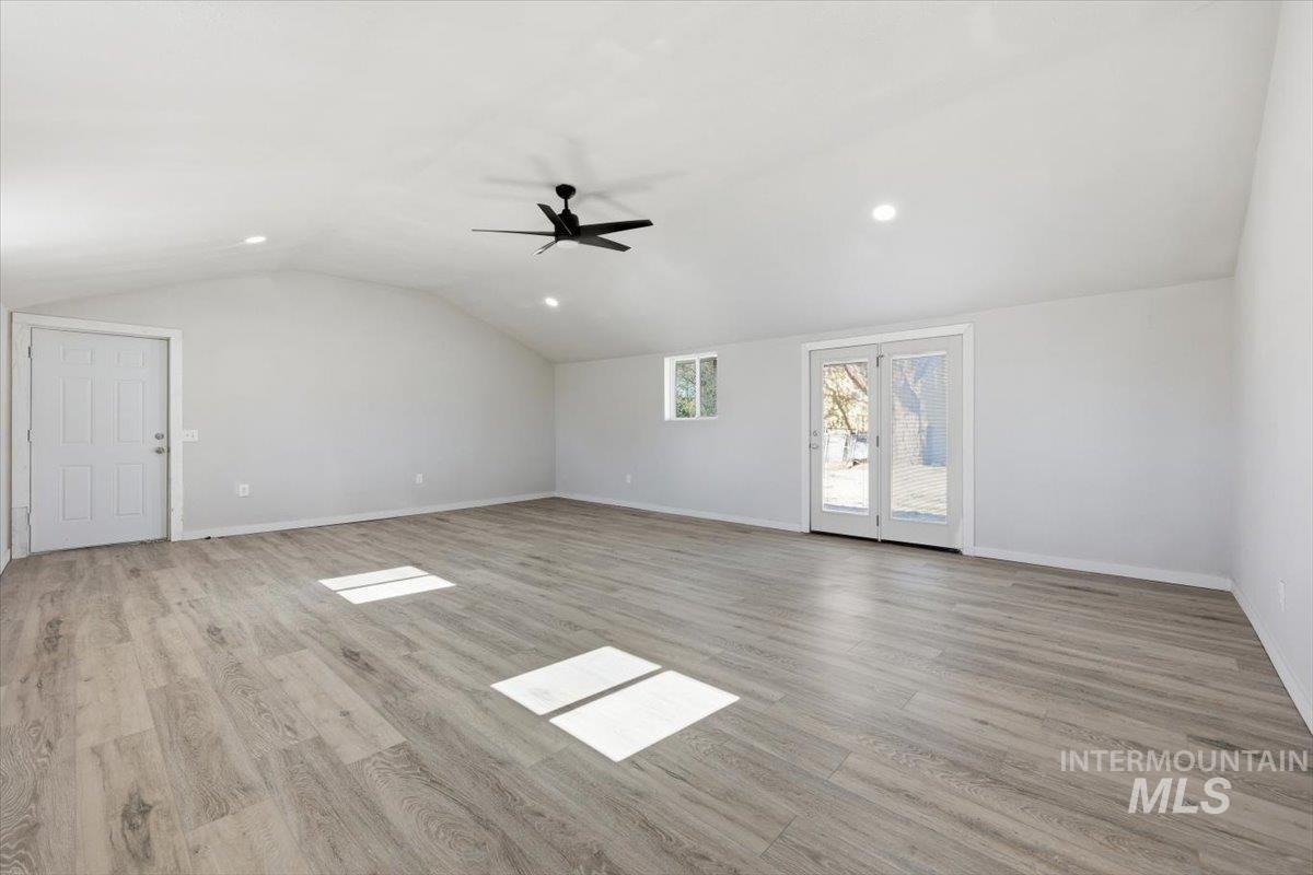 956 Southeast Hamilton Road Mountain Home, ID 83647 - Photo 22 of 34 Spacious room featuring wood-finish flooring, light grey walls, and a vaulted ceiling