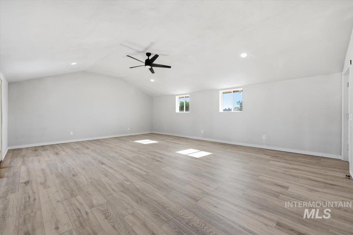 956 Southeast Hamilton Road Mountain Home, ID 83647 - Photo 23 of 34 Spacious room featuring wood-finish flooring, a vaulted ceiling, and recessed lighting