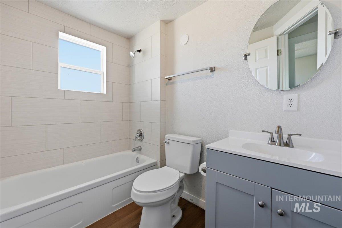 956 Southeast Hamilton Road Mountain Home, ID 83647 - Photo 26 of 34 Bathroom featuring a white tub, light-toned horizontal wall tiling, and a window above the tub